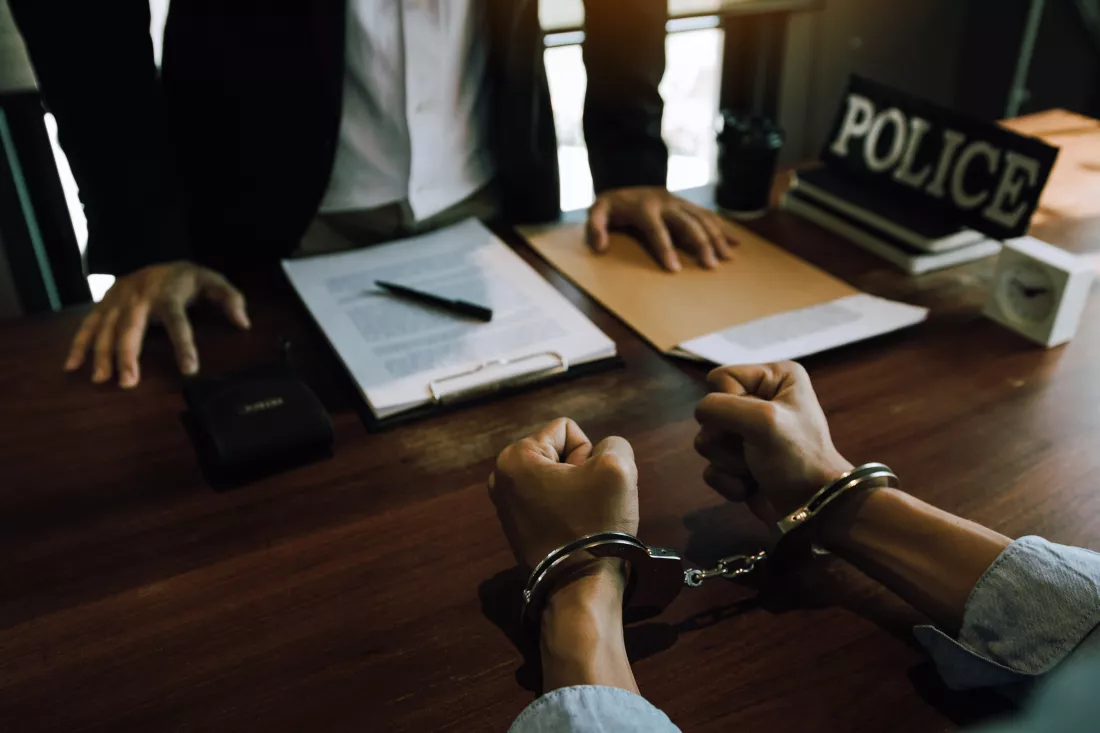 high-angle-view-police-officer-with-handcuffed-criminal-police-station
